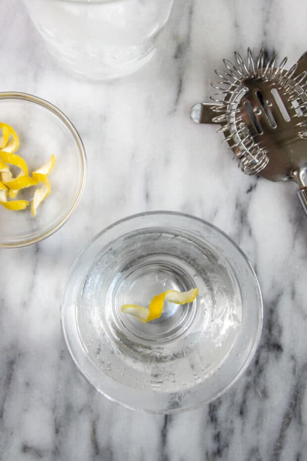 A gin martini with a lemon twist in a short martini glass.