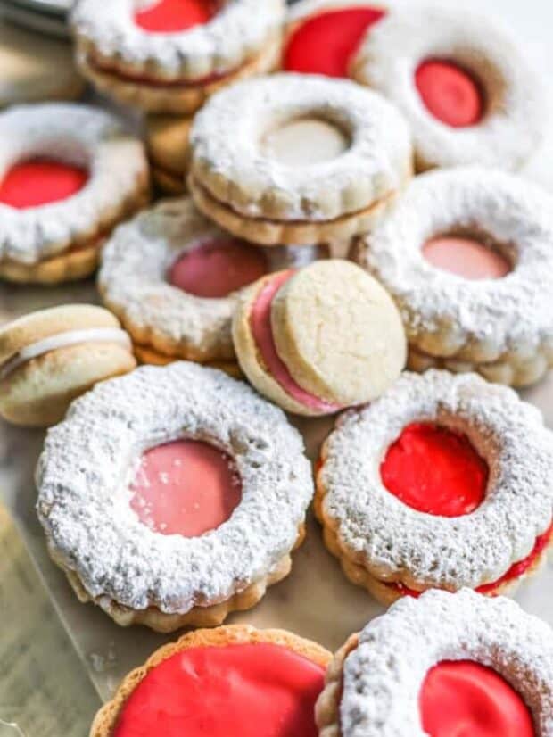 A plate of holiday decorated sugar cookies with red white and pink icing.