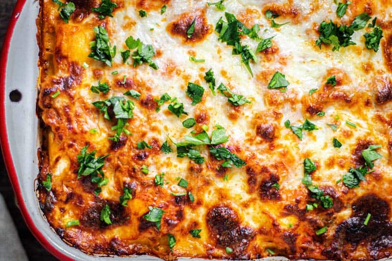 a white & red dish of ravioli bake