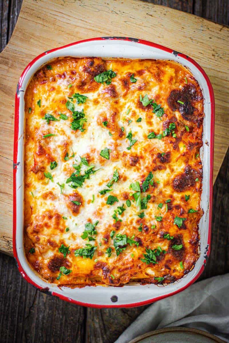 a white & red dish of ravioli bake