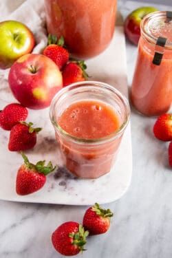 jar of strawberry applesauce on a marble background