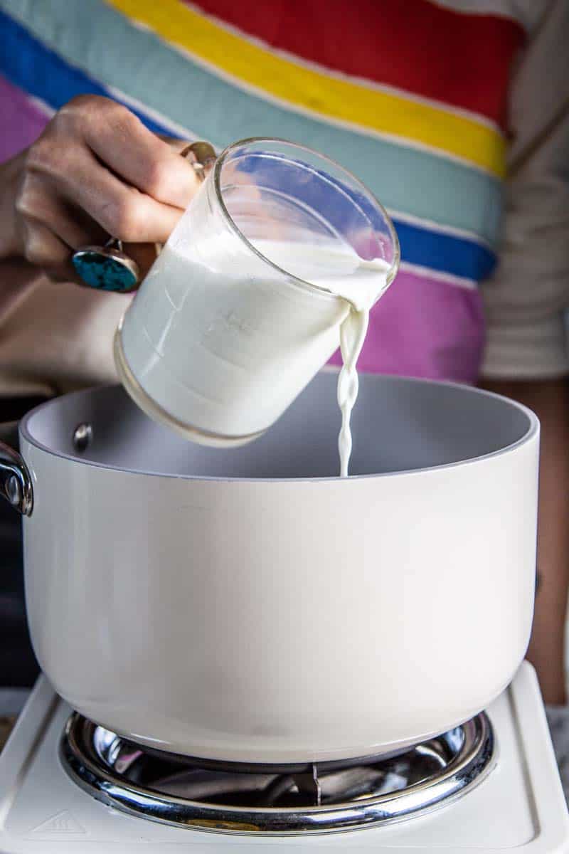 pouring heavy cream into pan