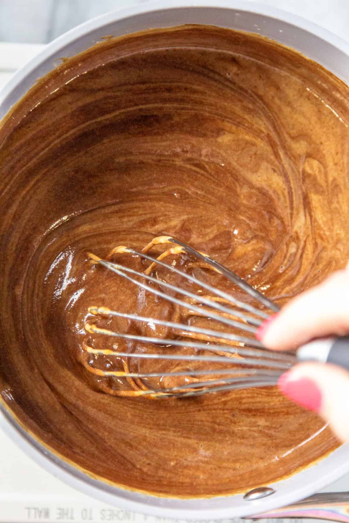stirring chocolate sauce with whisk