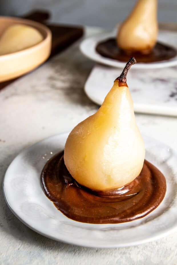 Place poached pears on top of hot fudge