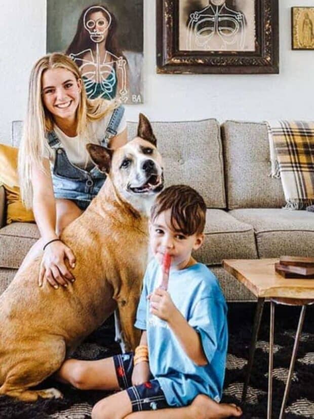 a girl, boy, & a dog sitting near a couch