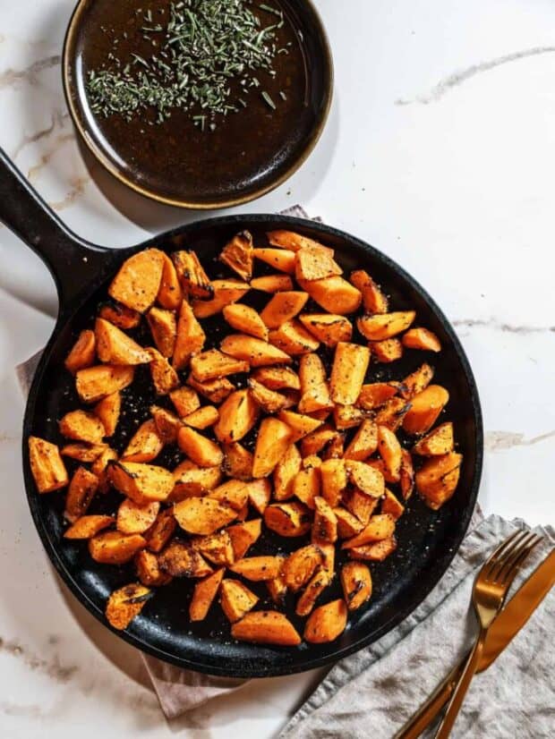 cooked carrots on a cast iron skillet on marble background