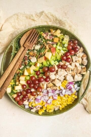 A large chopped salad in a green bowl.