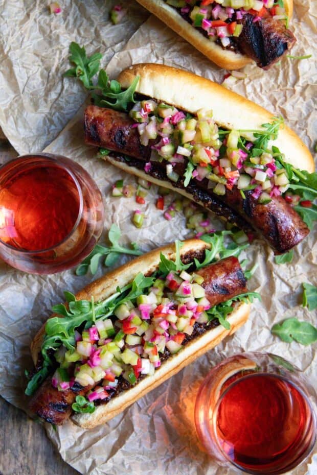 Homemade Celery Cucumber Relish Recipe on top of a sausage dog served with rose wine.