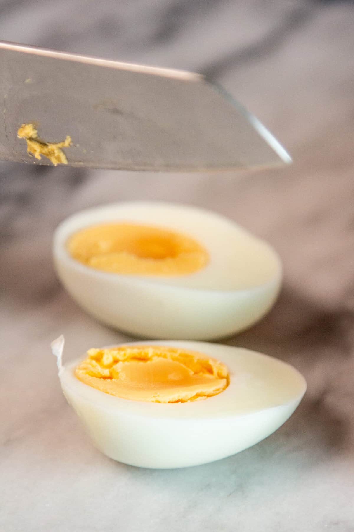 a hard boiled egg being cut open with a knife