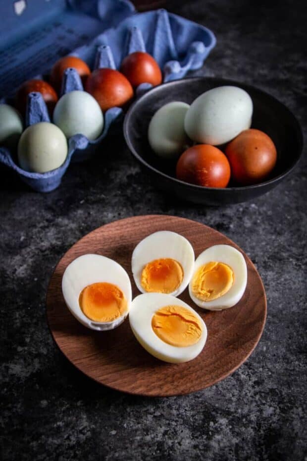 cut open hard boiled eggs next to egg carton