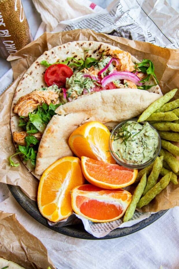 chicken gyros next to fruit and dried snap peas