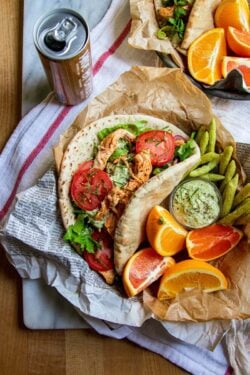 A pita bread stuffed with lettuce, tomatoes, red onion, tzatziki, and shredded Greek chicken.