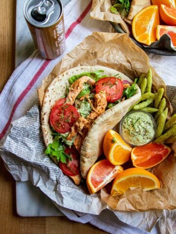 A pita bread stuffed with lettuce, tomatoes, red onion, tzatziki, and shredded Greek chicken.