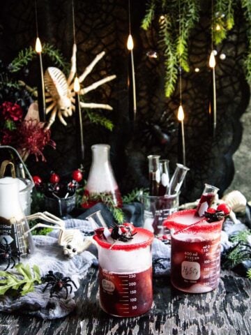 A spooky Halloween set up with spider decorations and cocktails fizzing and bubbling with dry ice.