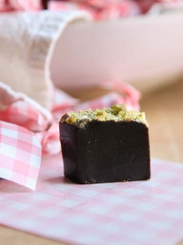 A piece of caramel with minced pistachios on top.