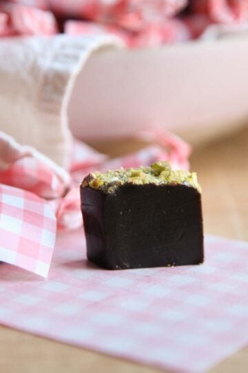 A piece of caramel with minced pistachios on top.