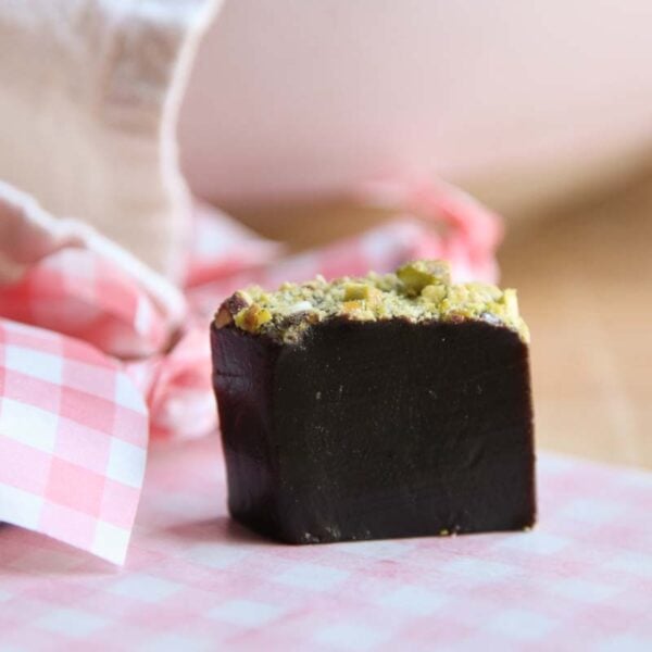 A piece of caramel with minced pistachios on top.