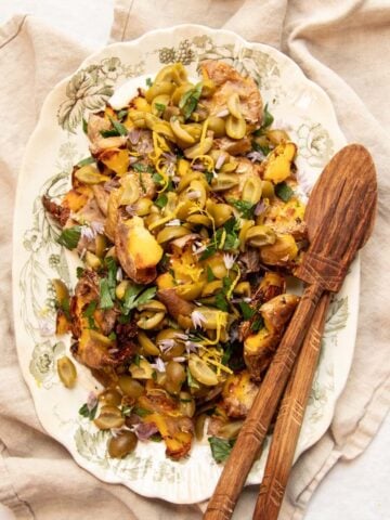 A platter of Crispy Smashed Potatoes with Dirty Martini-Infused Olive Topping ready to serve.