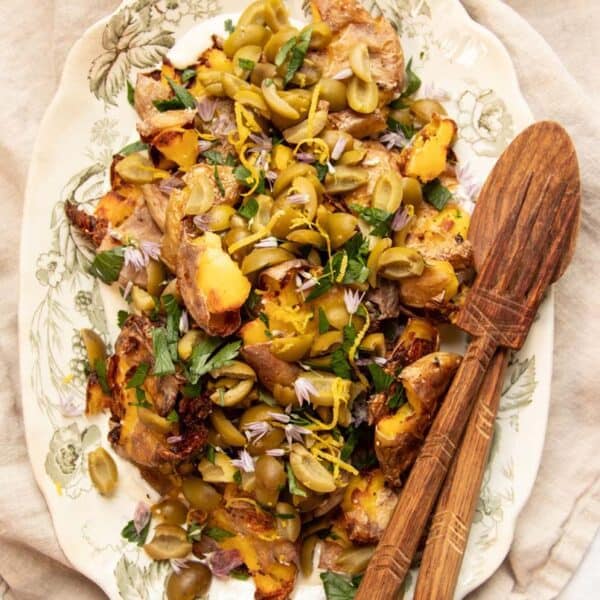 A platter of Crispy Smashed Potatoes with Dirty Martini-Infused Olive Topping ready to serve.