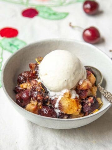 A bowl of Cherry Brown Betty with vanilla ice cream.
