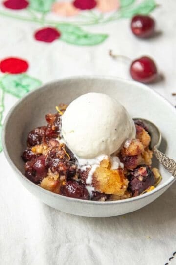 A bowl of Cherry Brown Betty with vanilla ice cream.